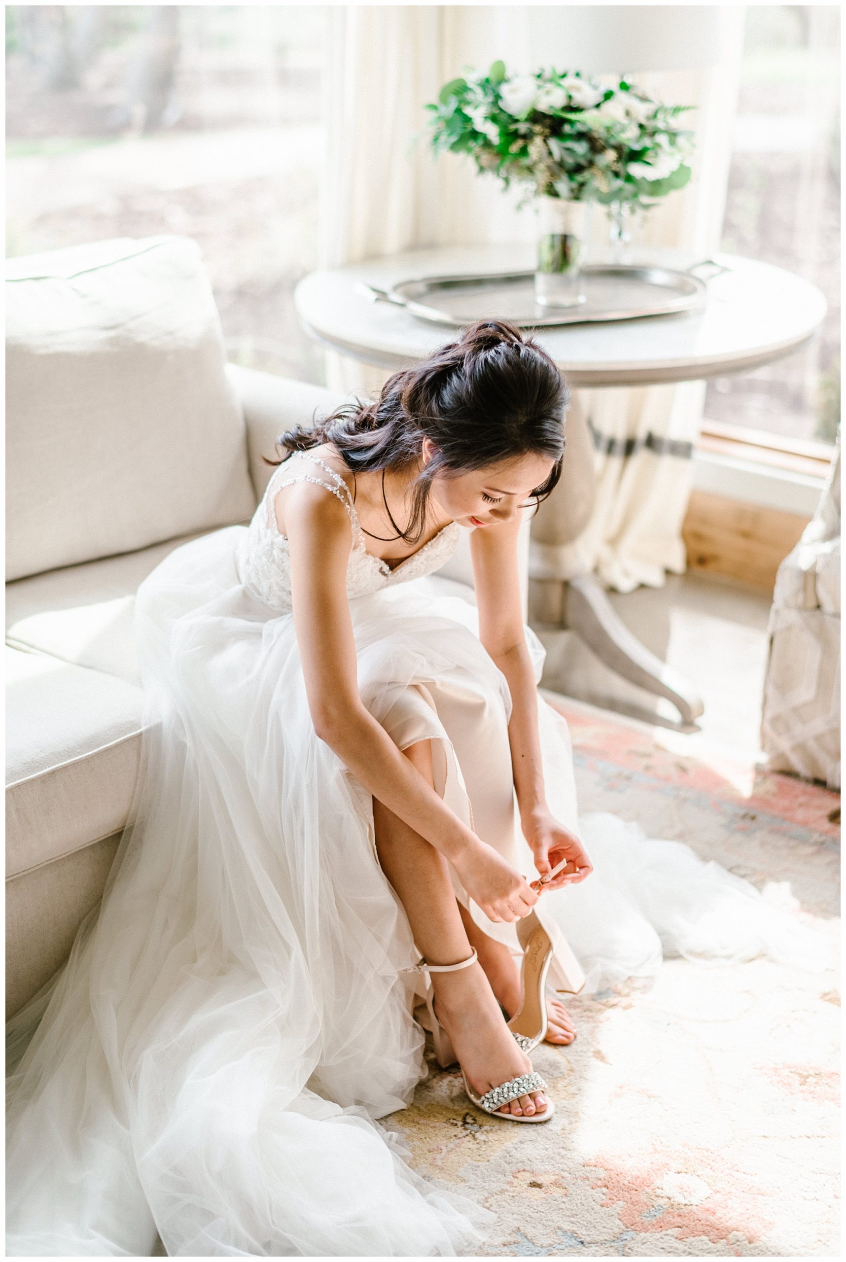 Bride putting on wedding shoes in gorgeous bridal suite