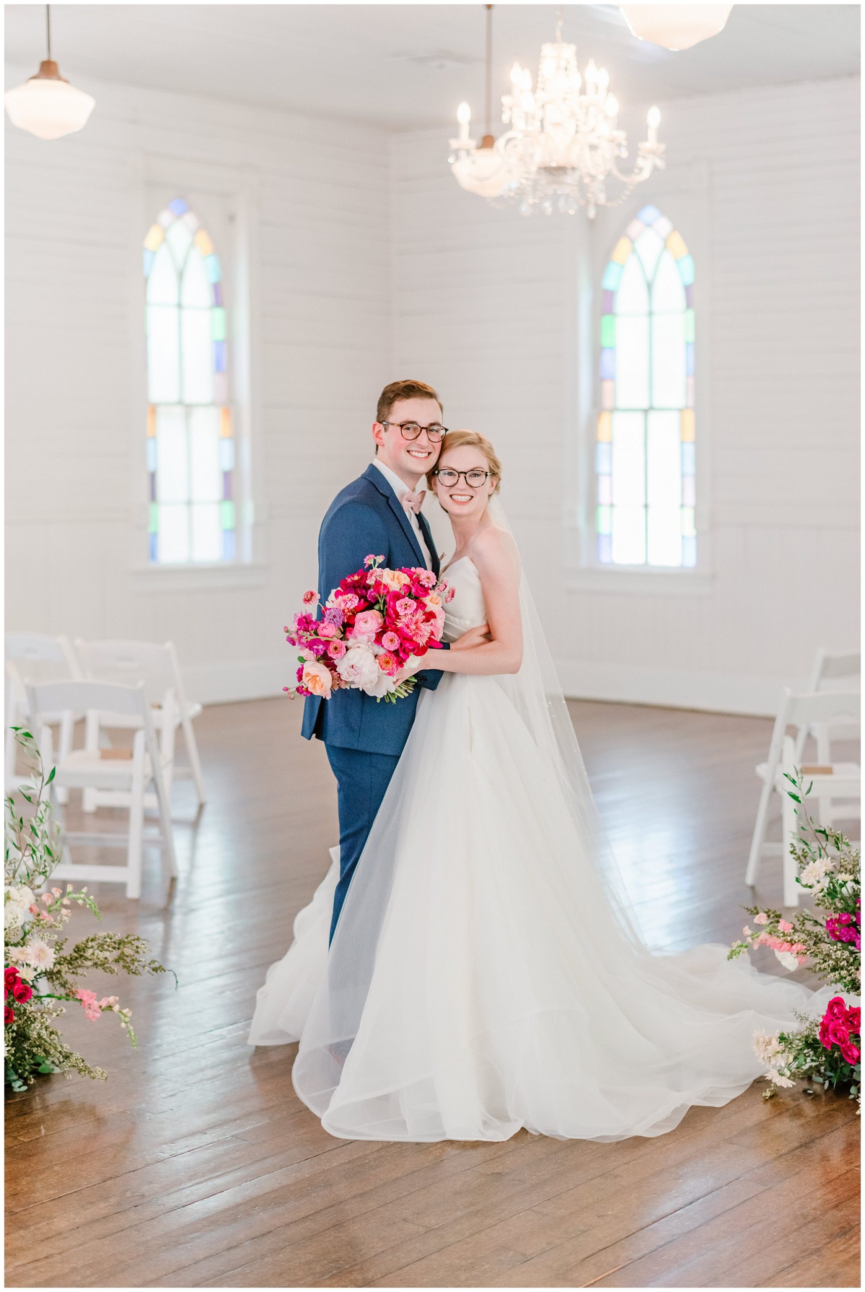 beautiful bride with fuchsia rose and blush florals and groom in navy blue suit couples portraits