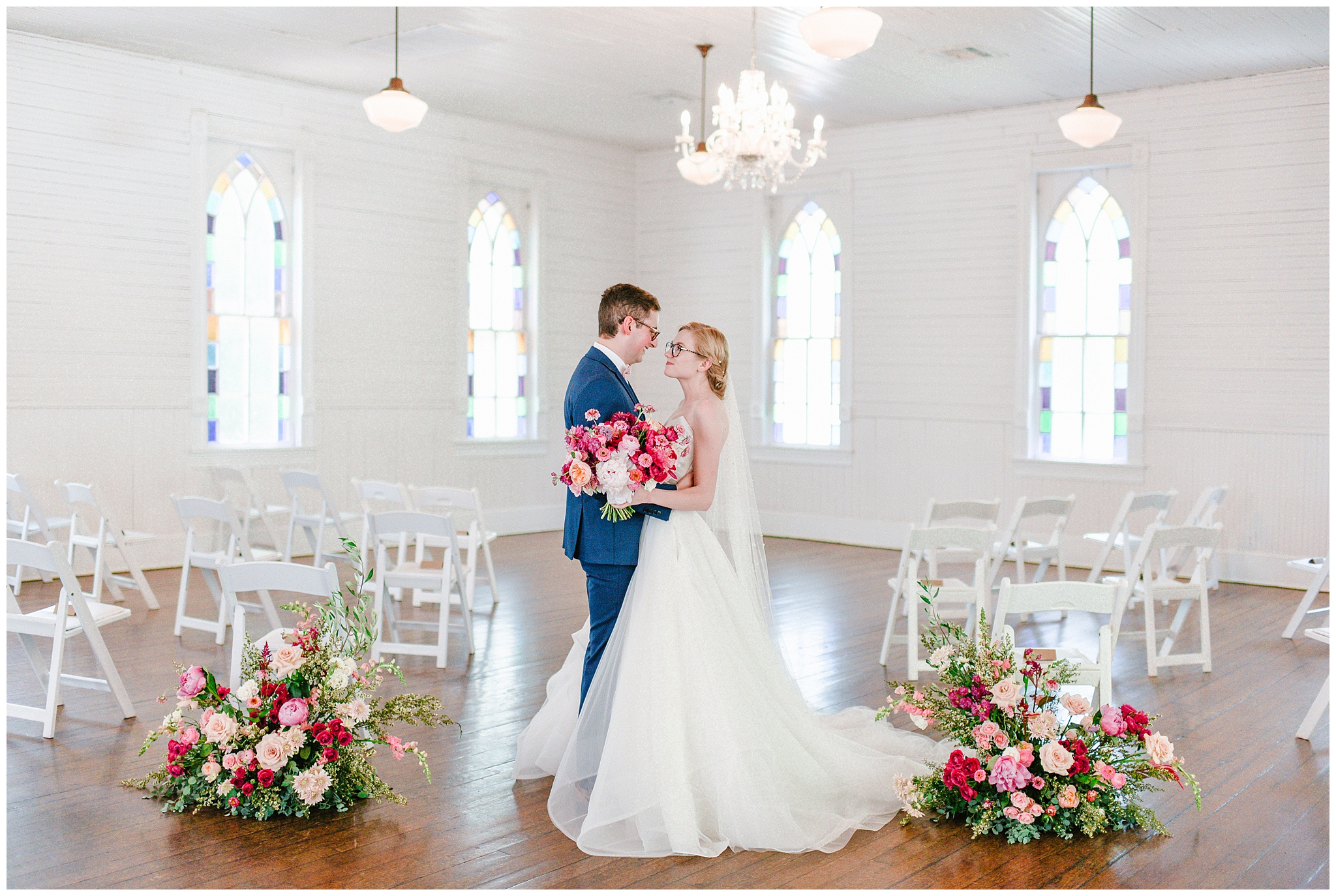 beautiful bride with fuchsia rose and blush florals and groom in navy blue suit couples portraits