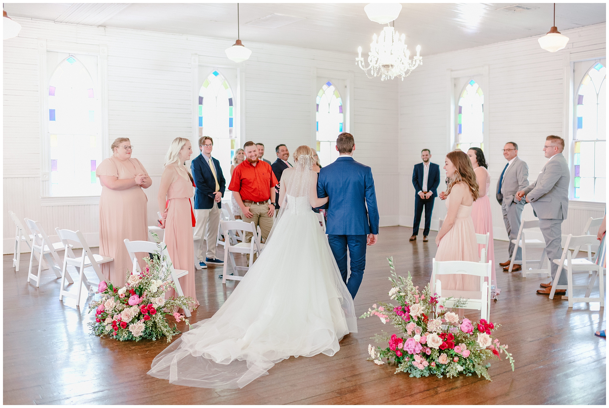 beautiful bride with fuchsia rose and blush florals and groom with navy blue suit wedding ceremony